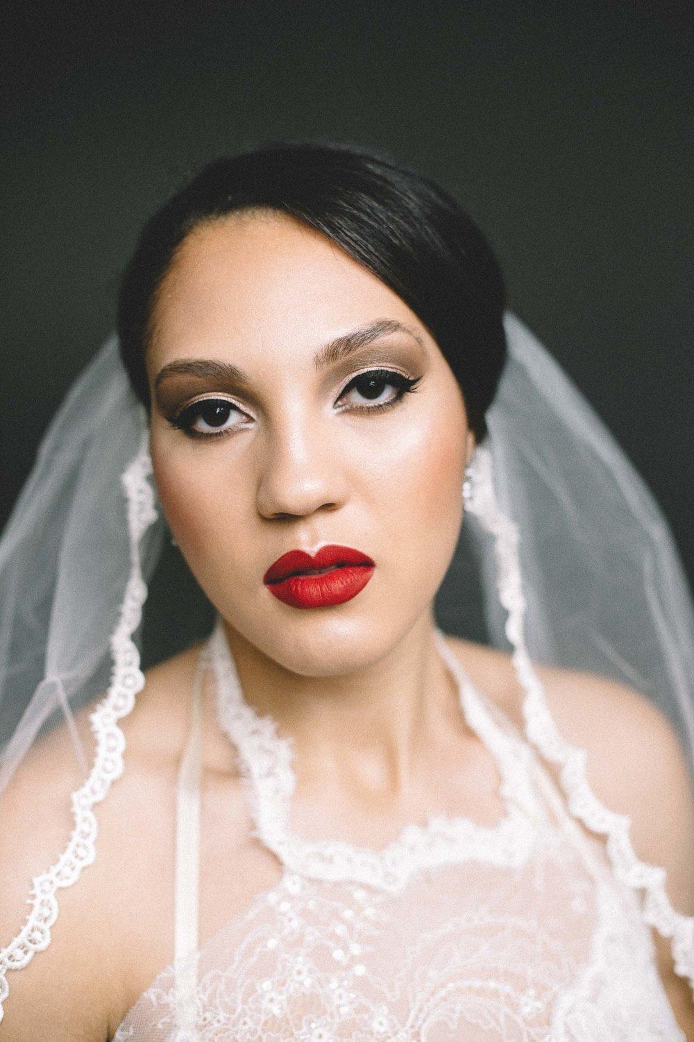 Black bride with glamorous wedding makeup smokey eye with winged liner and red lipstick