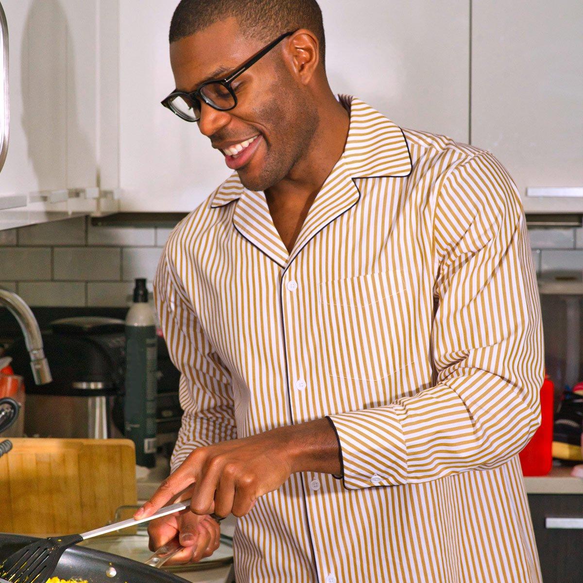 Man wearing comfy striped pajamas from Tie Bar while cooking 