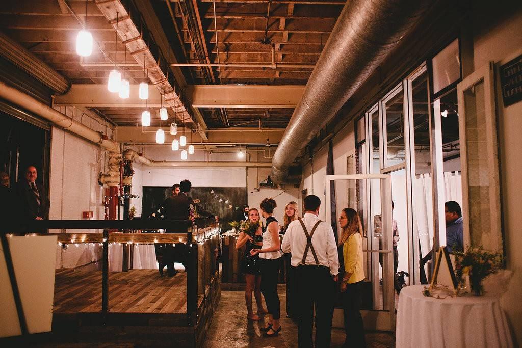 industrial space with exposed pipework and people enjoying reception