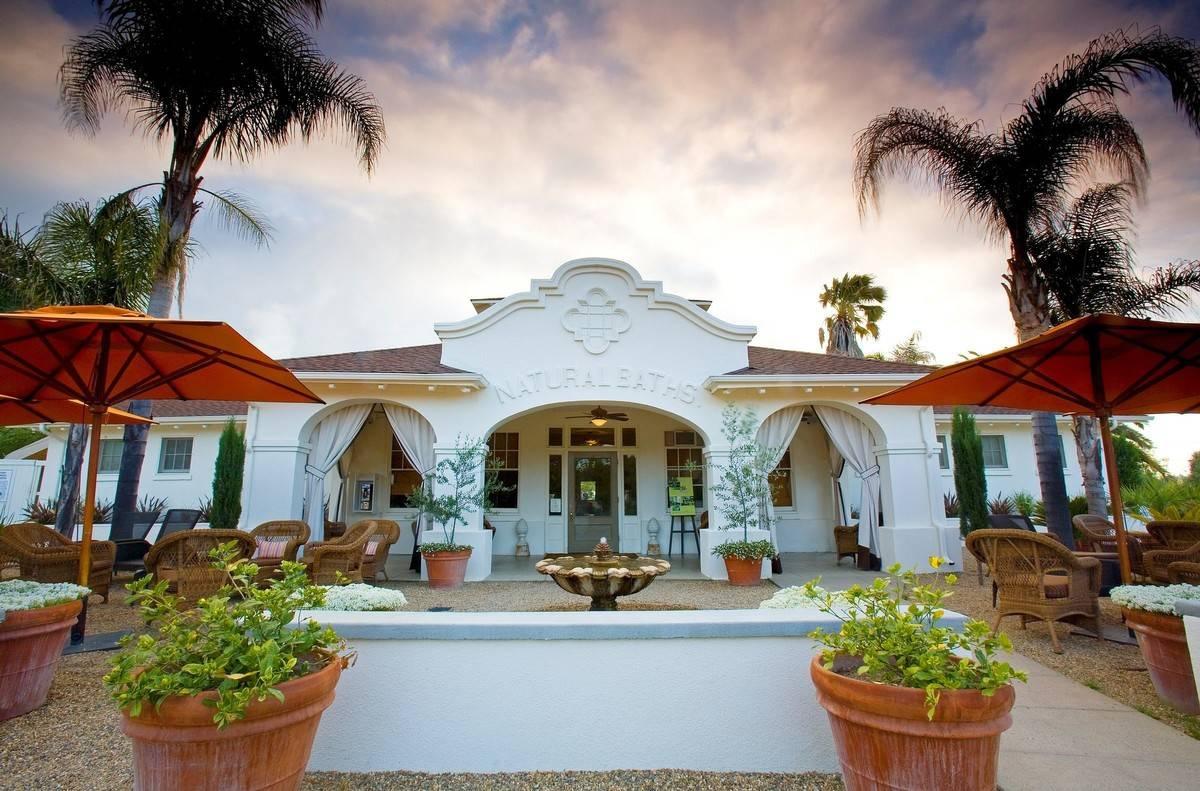 napa wedding venue white Spanish-style building with gravel courtyard and patio tables with umbrellas scattered around
