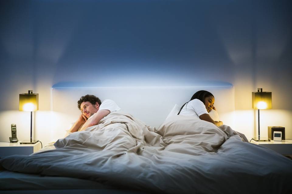 couple in bed looking in opposite directions