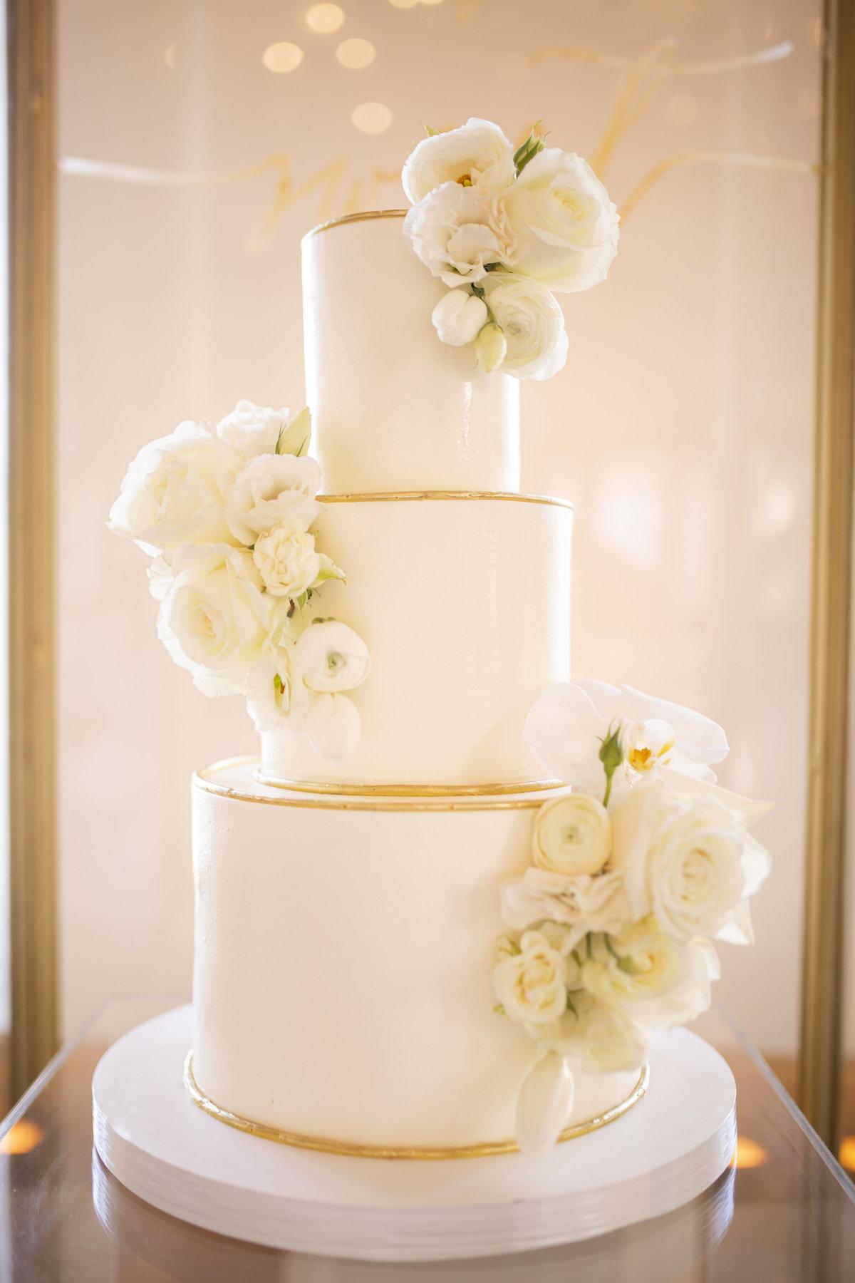 Three-Tier White Wedding Cake With Combed Buttercream and White Flowers