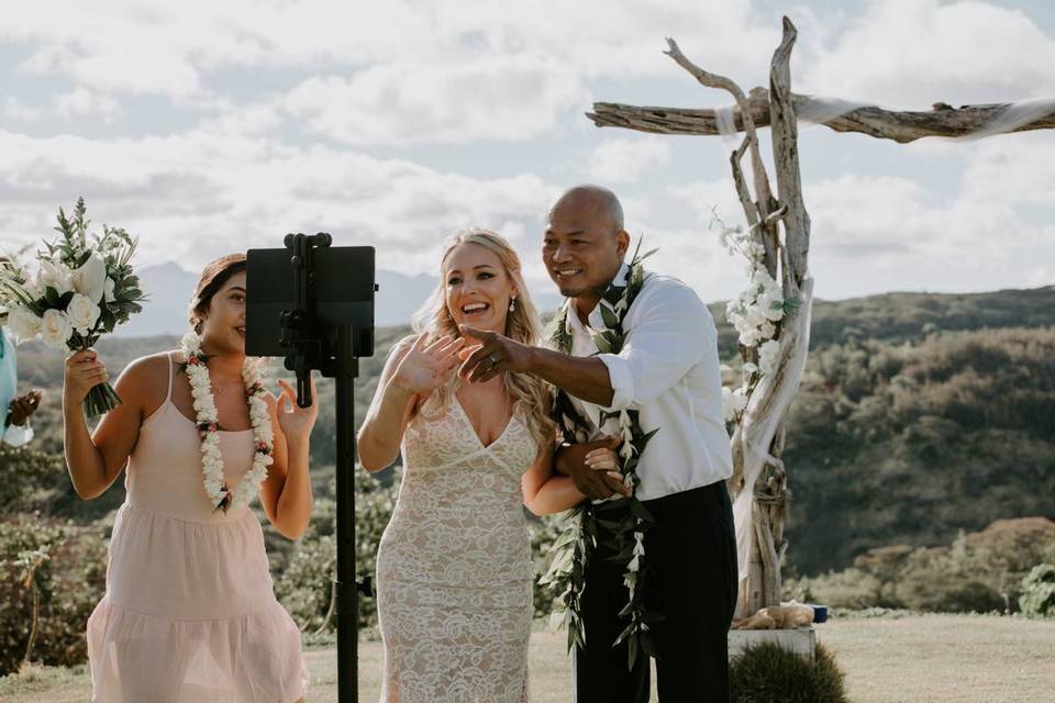 couple pointing at tablet screen and smiling at wedding