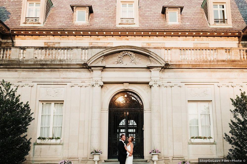 bride and groom standing outside historic home