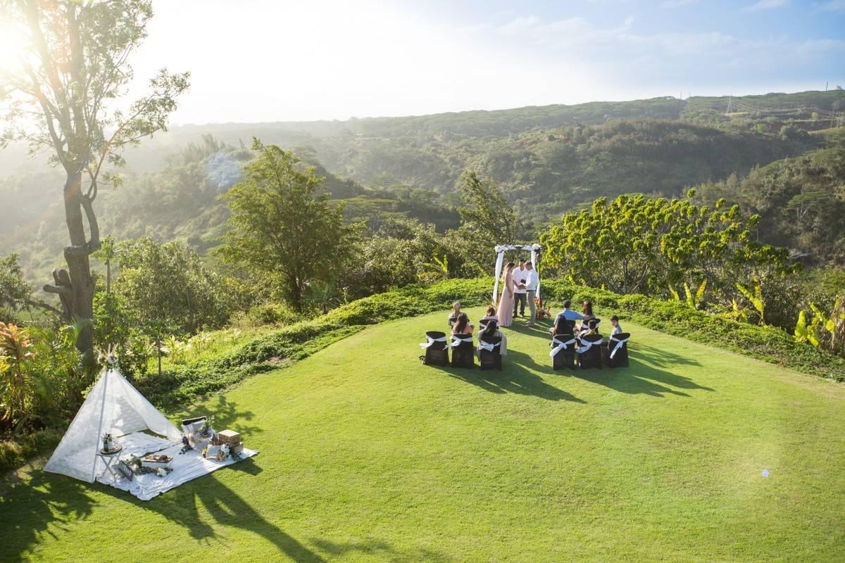 small wedding ceremony in hawaii on top of mountain overlooking forests below