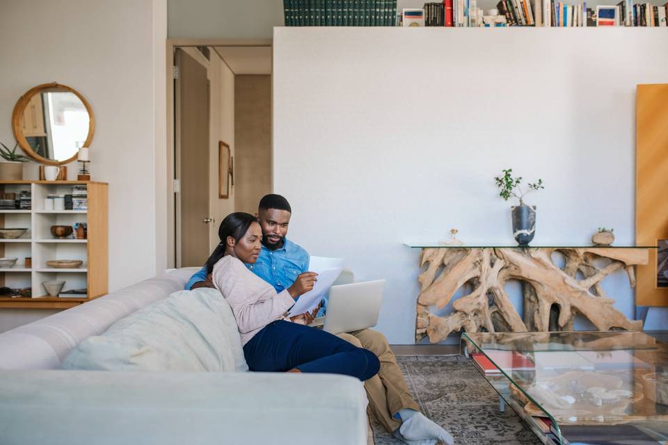 couple looking at papers while sitting on the couch