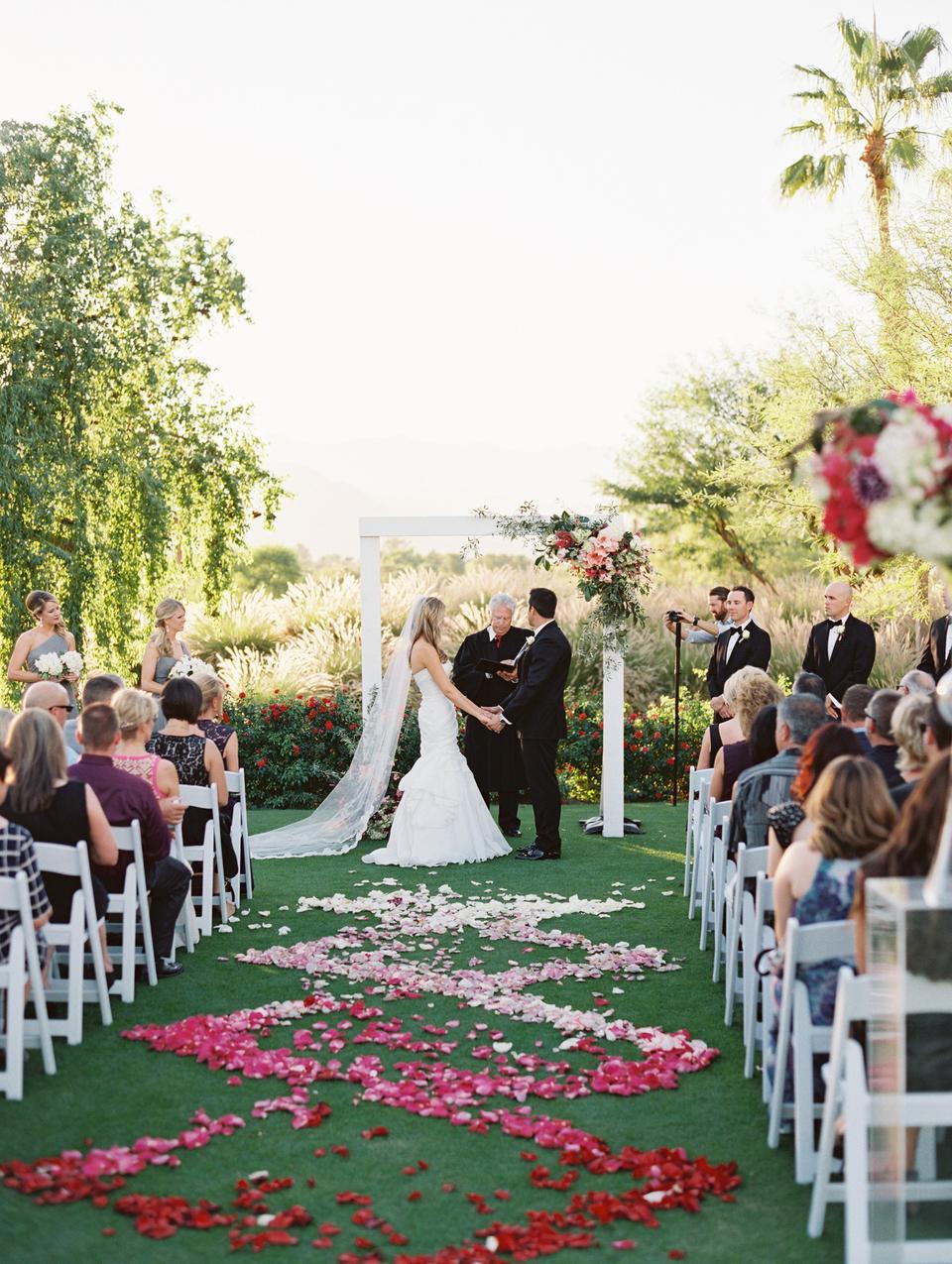 glam outdoor wedding aisle decor ombre pink and red rose petals in swirled pattern down the aisle