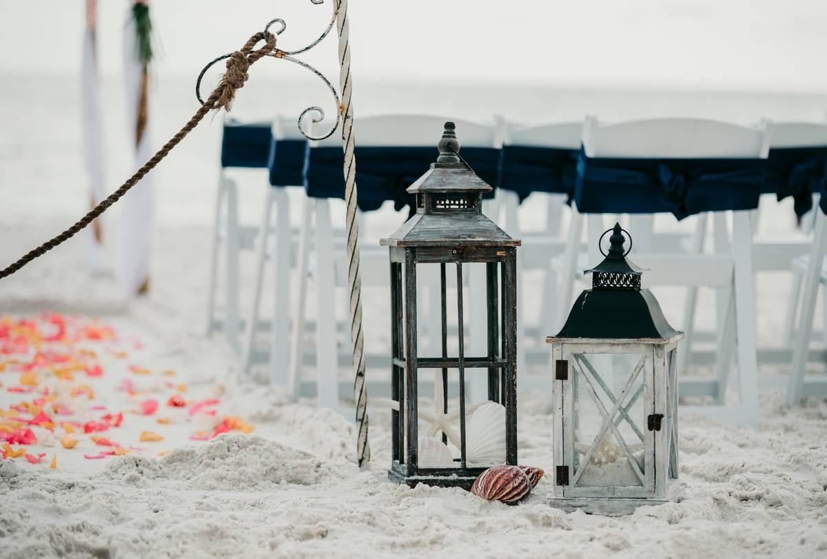beach wedding ceremony decor with vintage lanterns and seashells as aisle markers