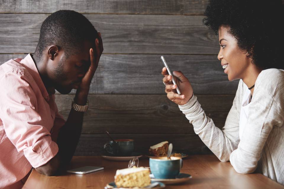 woman on phone ignoring exasperated man