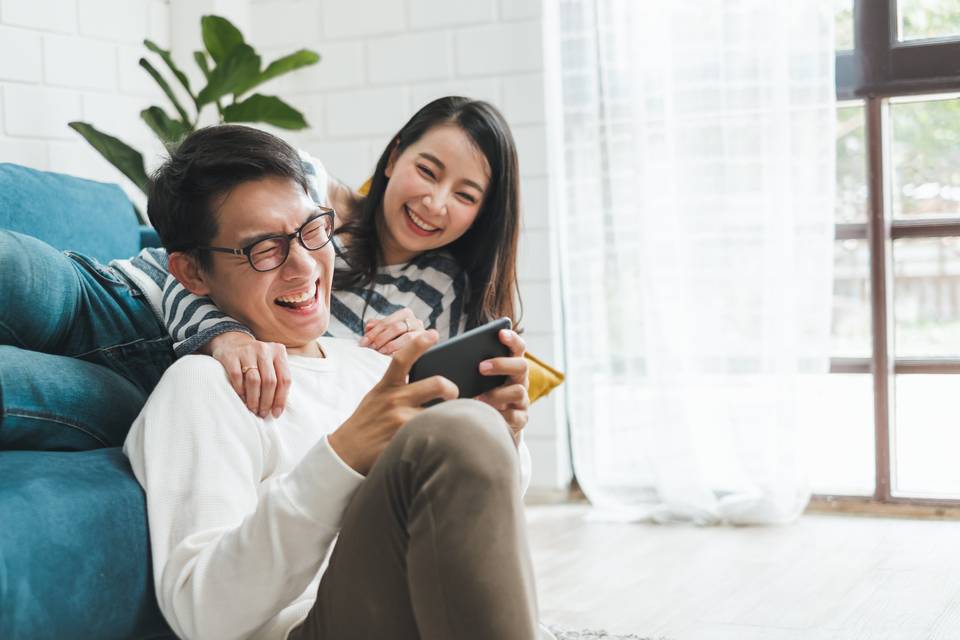 couple looking at a phone together and laughing