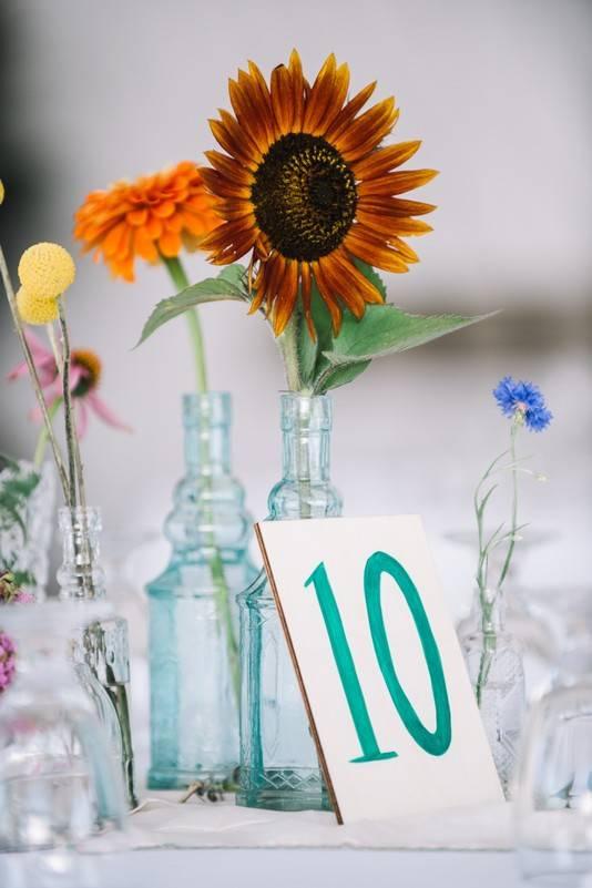 sunflower and wildflower wedding centerpiece with hand-painted table number