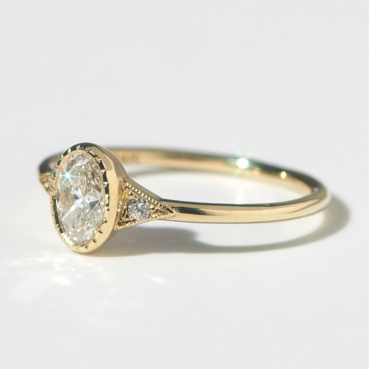 Minimalist three-stone diamond engagement ring with yellow gold band