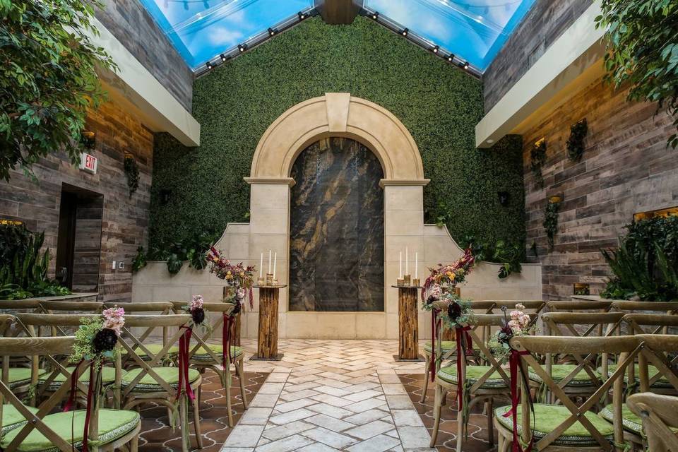 las vegas wedding chapel with skylights and garden-inspired decor featuring moss wall behind the altar and brick flooring
