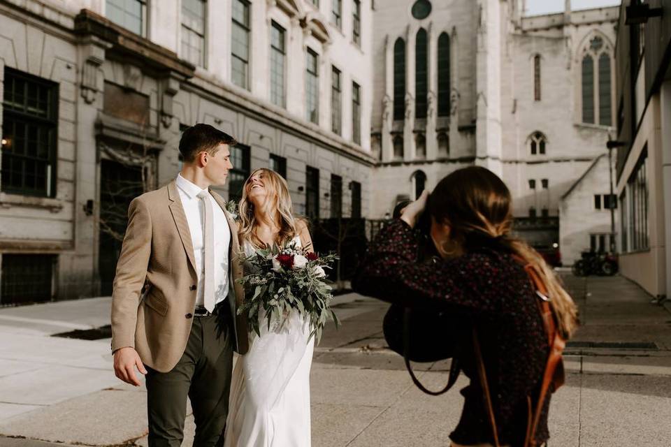 wedding photographer taking a photo of happy couple