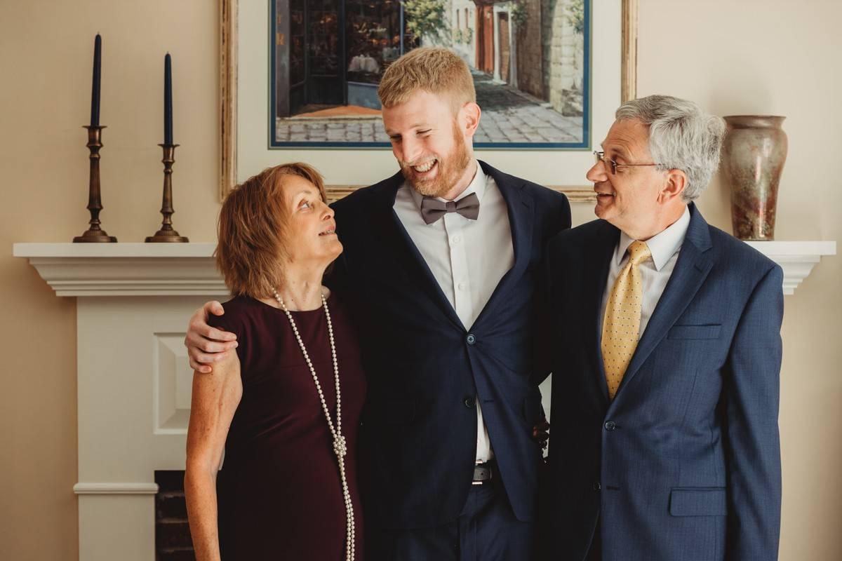 groom with arms around his parents