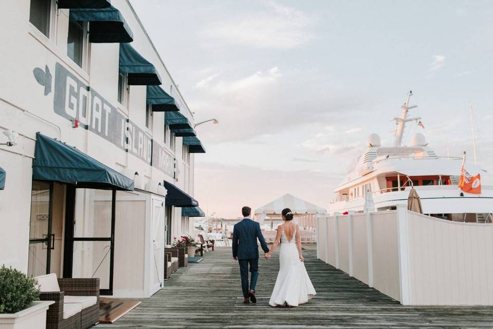 groom and bride walking down dock