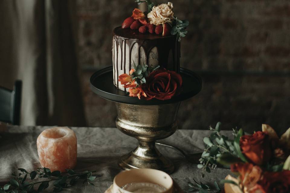 fall wedding cake with chocolate drip icing and fresh roses on top