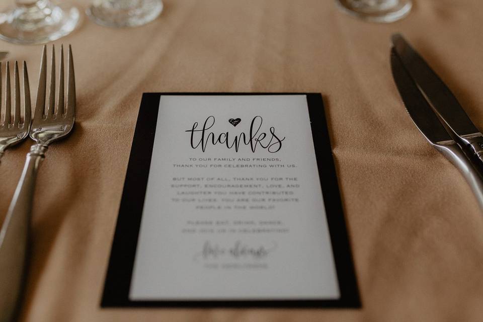 wedding thank you card is displayed at guest's reception table setting