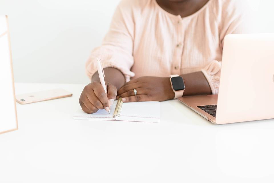 woman's hand writing in a notebook