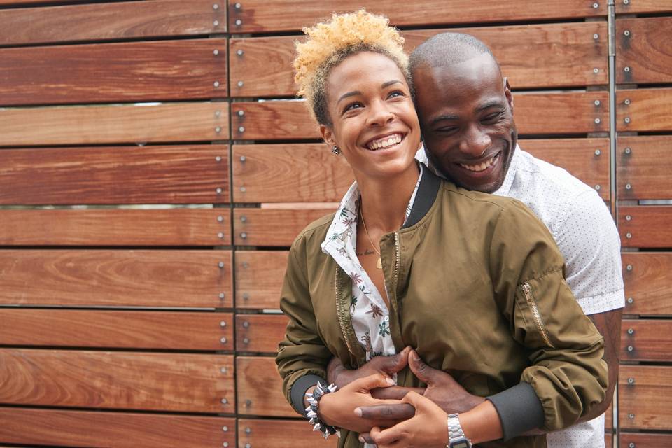 couple standing against a wooden wall