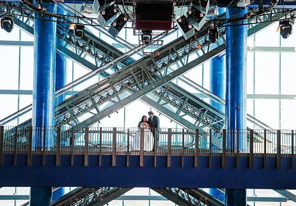 bride and groom standing in front of escalators