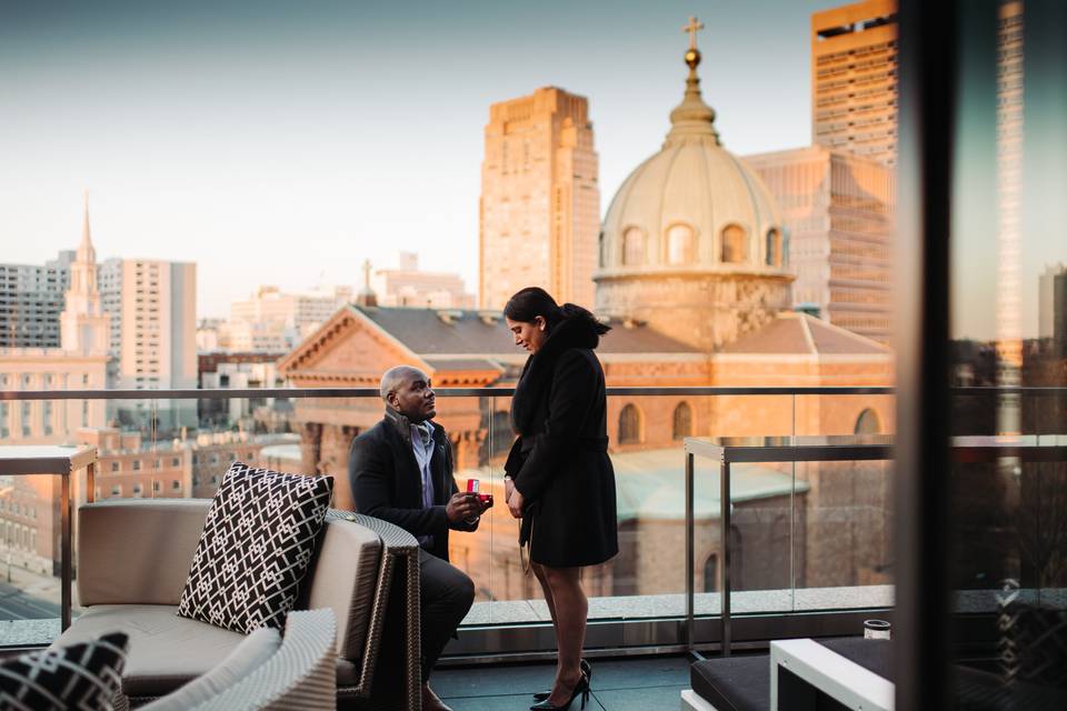 man proposing to woman on a philadelphia rooftop