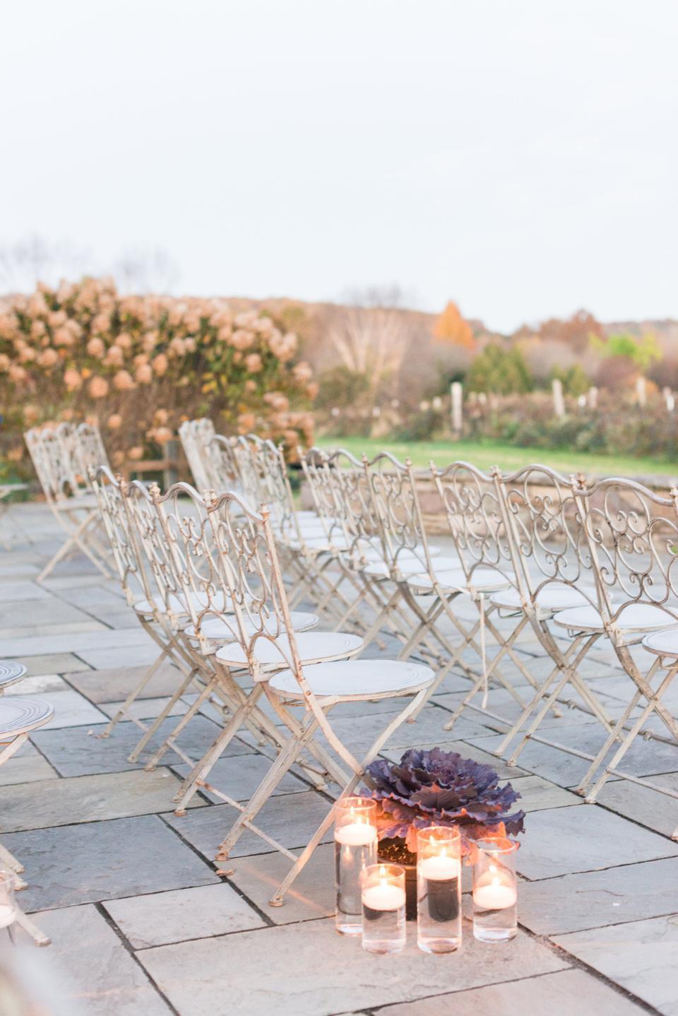 romantic outdoor wedding aisle decor idea floating candles in glass vases with ornamental cabbage flower arrangement