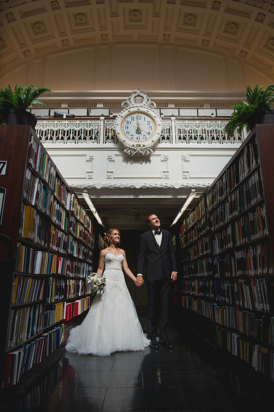 bride and groom holding hands while standing in library aisle at DAR hall washington dc