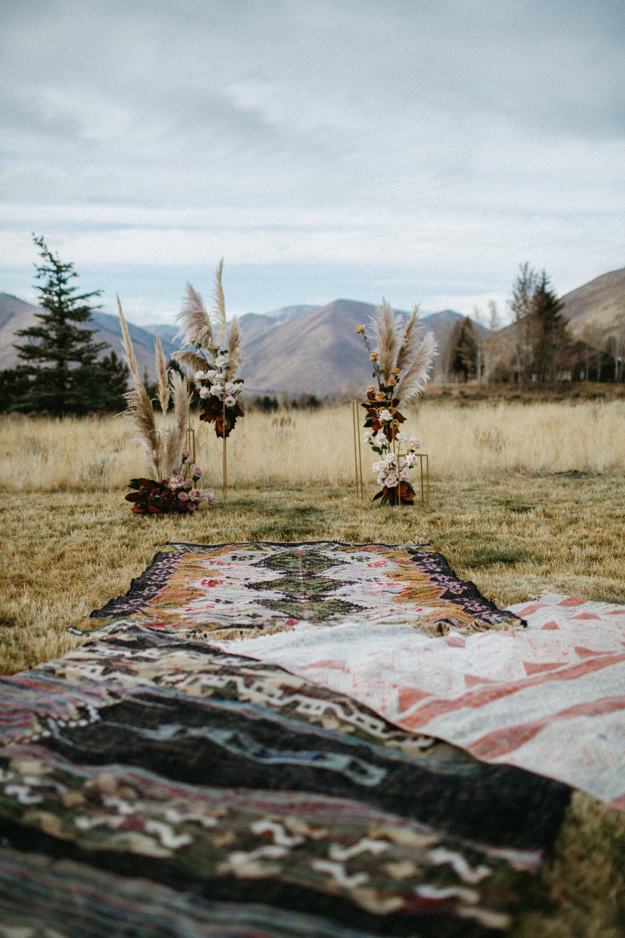 boho outdoor wedding aisle decor vintage geometric patterned rugs layered along the aisle