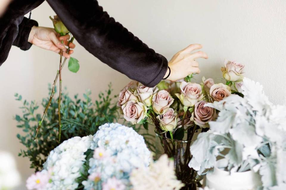 florist picking roses out of a glass vase