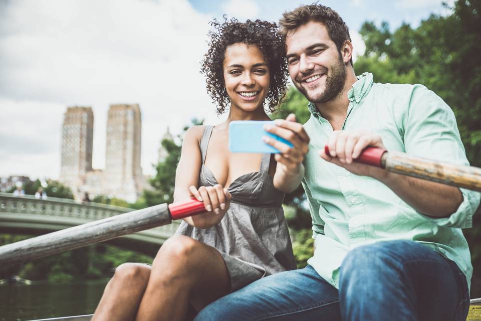 man and woman taking selfie on rowboat