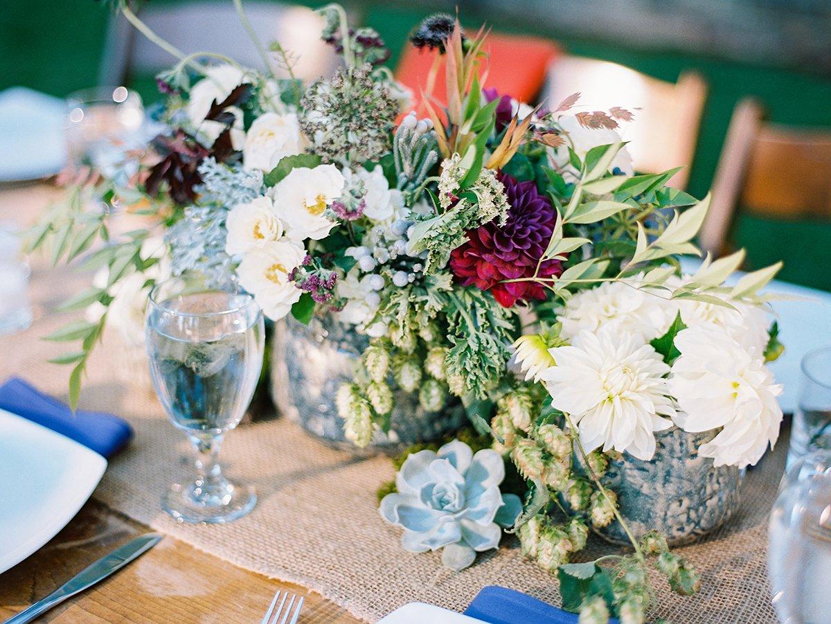 Tablescape with a moss runner, flowers and lanterns and blush