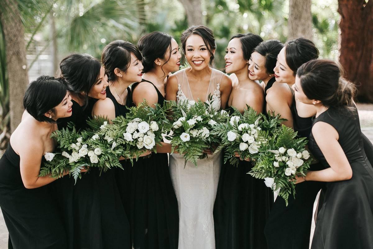 Bridesmaids wearing black dresses in photo op with bride