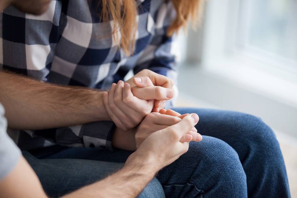 couple holding hands in support