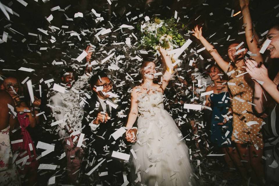 groom and bride showered with confetti