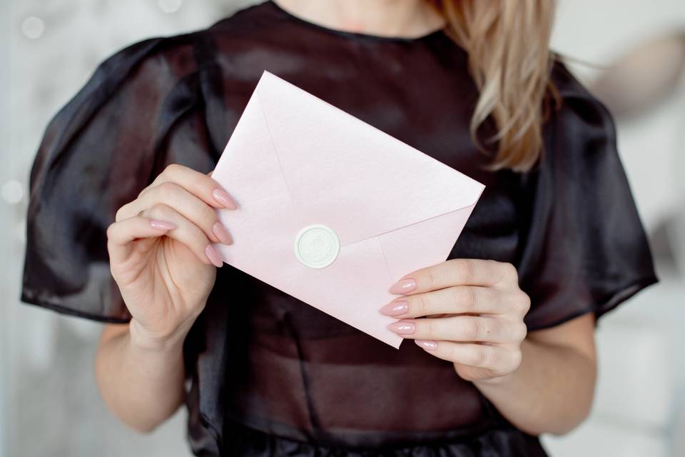 woman holding pink envelope