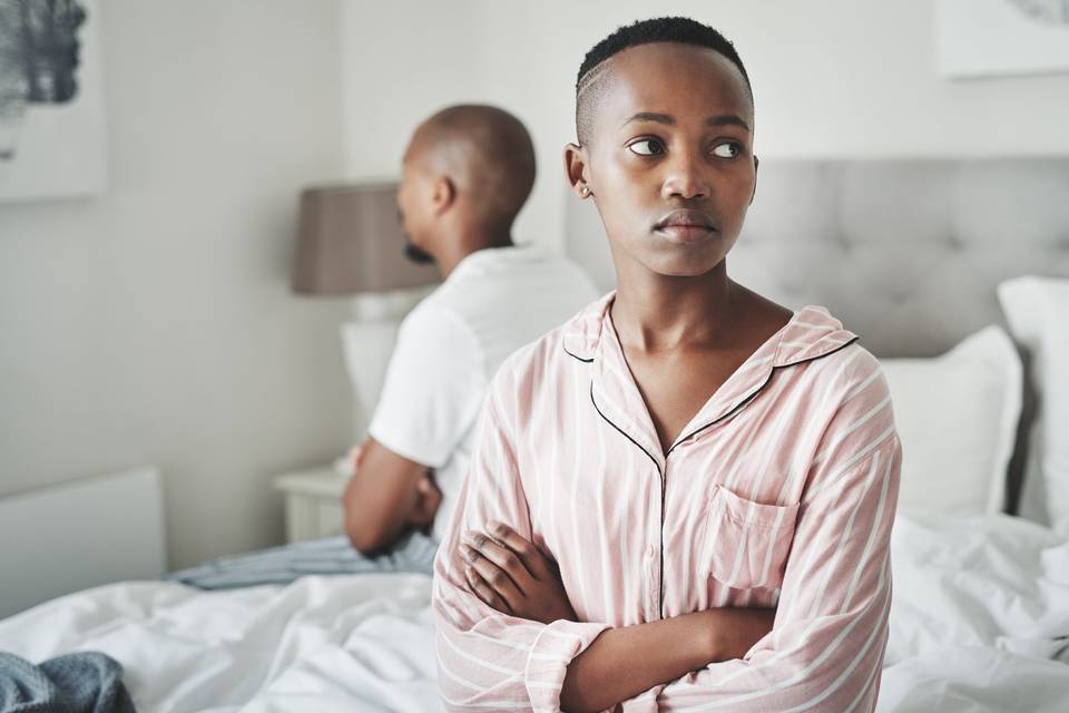 woman looking sad while sitting on bed