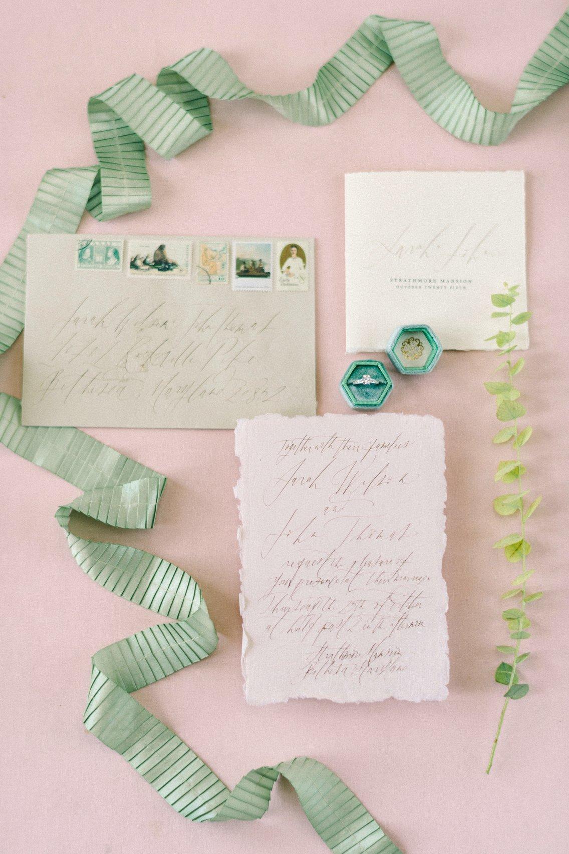 blush and light green wedding flat lay with calligraphy envelope