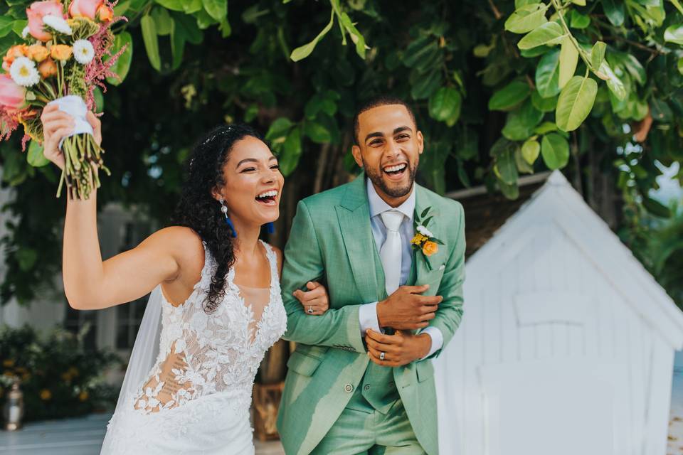 bride and groom laugh as they walk arm in arm