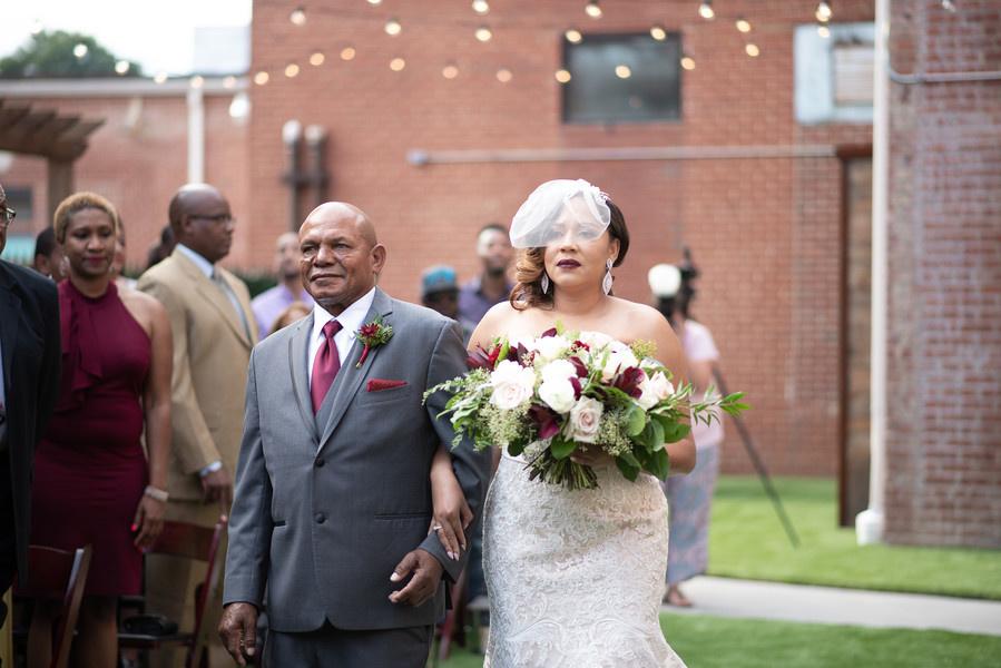 Bride and father walking down the aisle with guests watching wearing fall colors