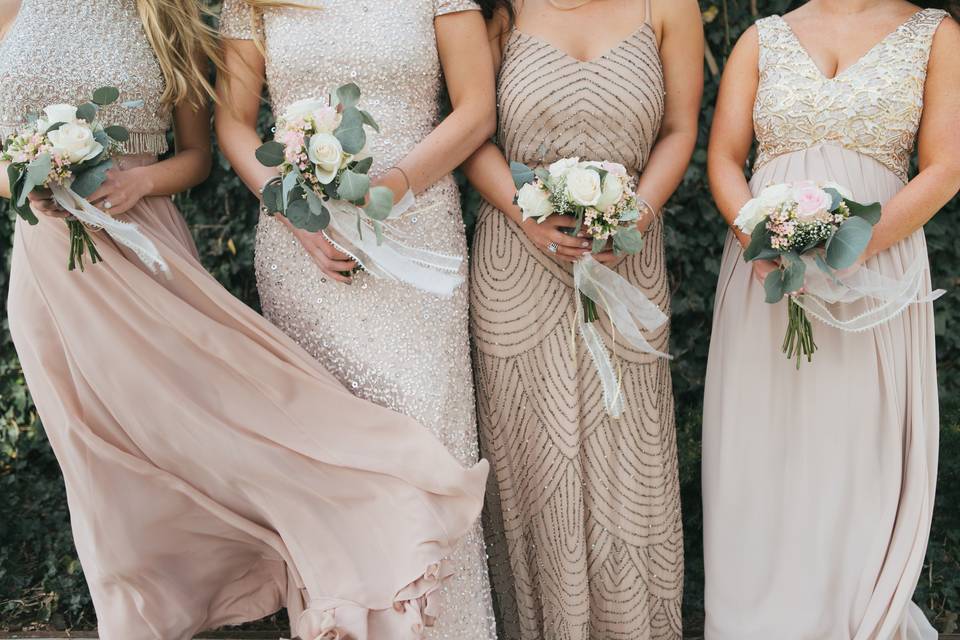 bridesmaids wearing gold dresses and carrying small white bouquets