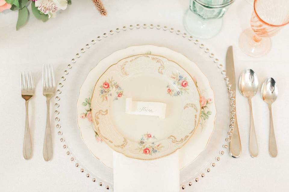 wedding reception place setting with vintage floral china and silverware