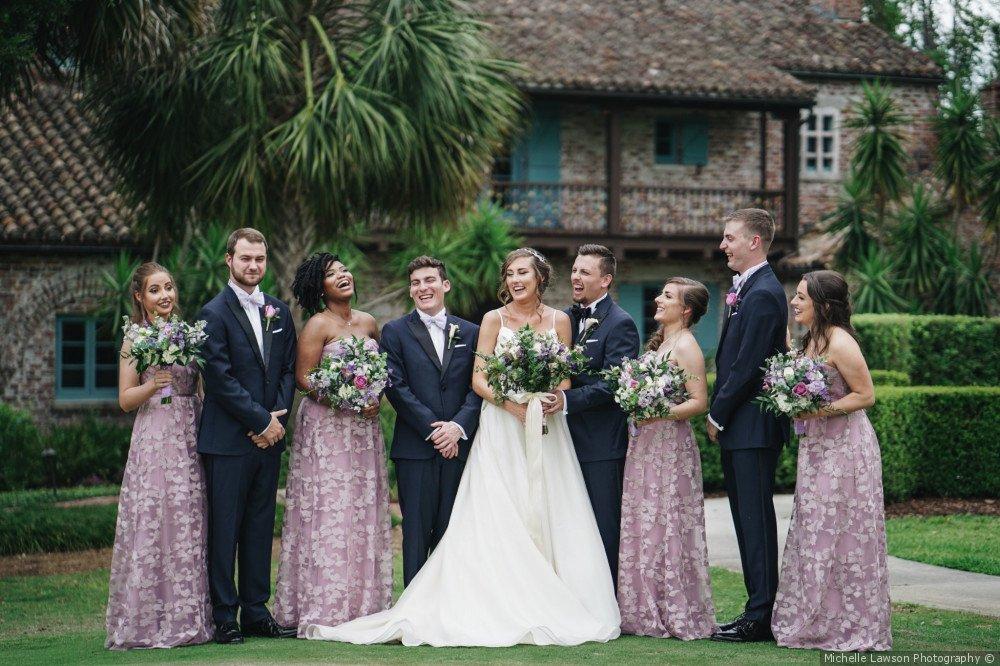 Wedding party photo with bridesmaids wearing patterned purple dresses