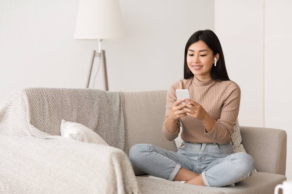 women sitting on couch listening to podcast