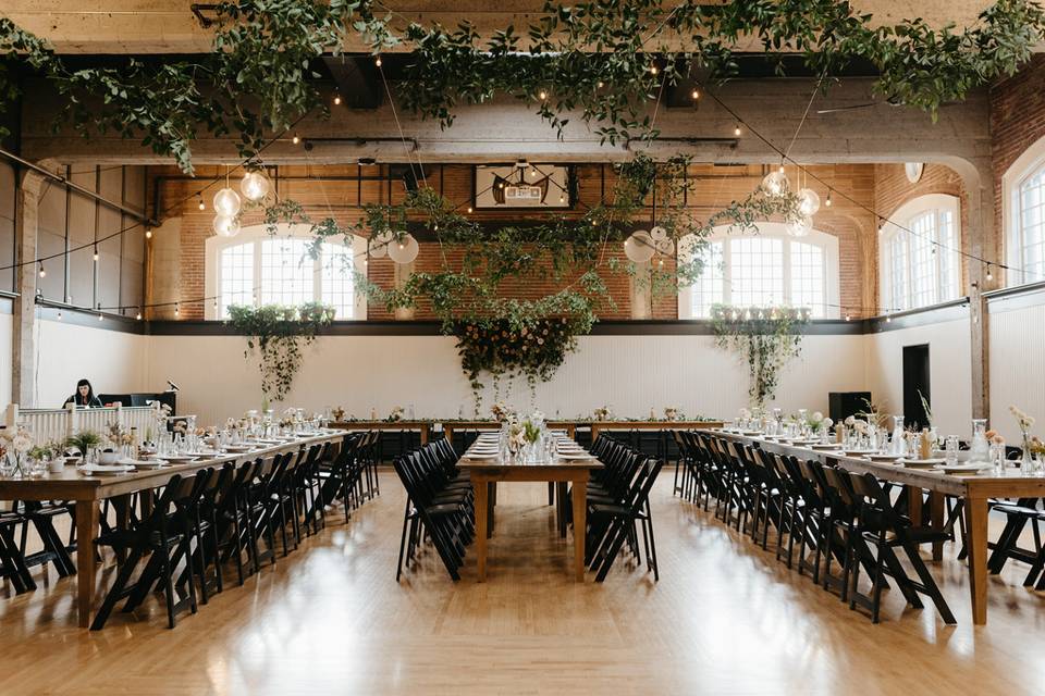 indoor reception space with greenery garlands hanging from the ceiling
