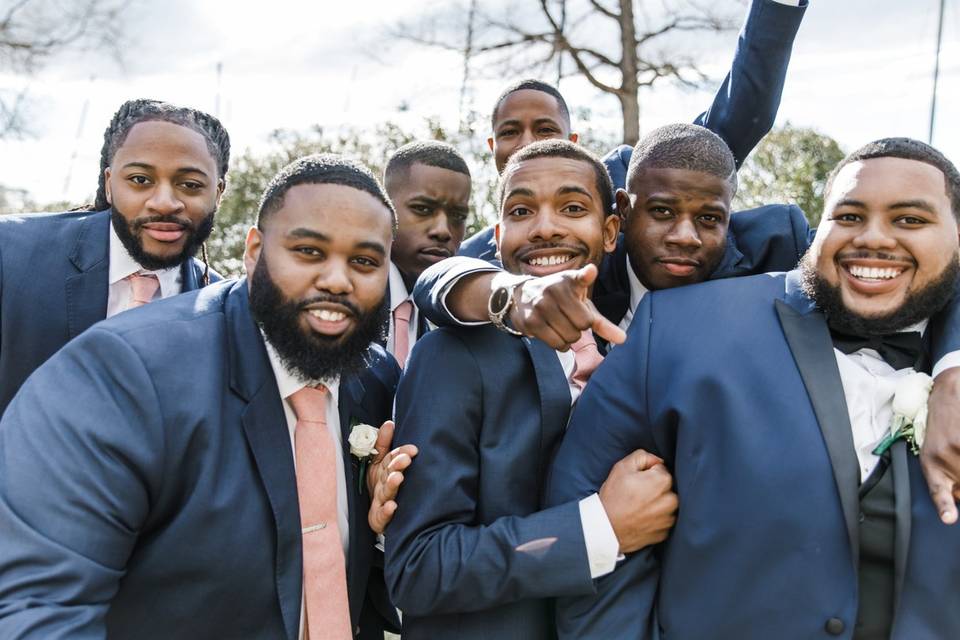 groom and his groomsmen gather for a huddle and wear matching blue tuxedos