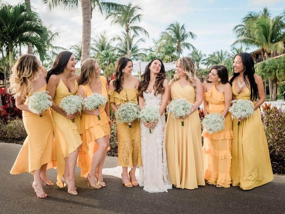 bride standing next to bridesmaids who are wearing mix-and-match yellow dresses