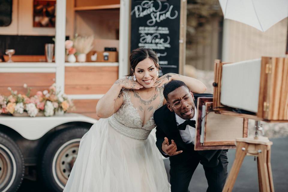 bride and groom taking a selfie at a photo booth 