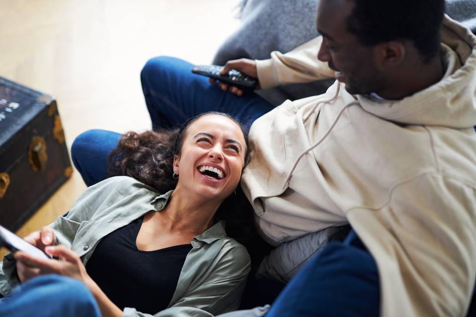 couple relaxing on couch look at phone