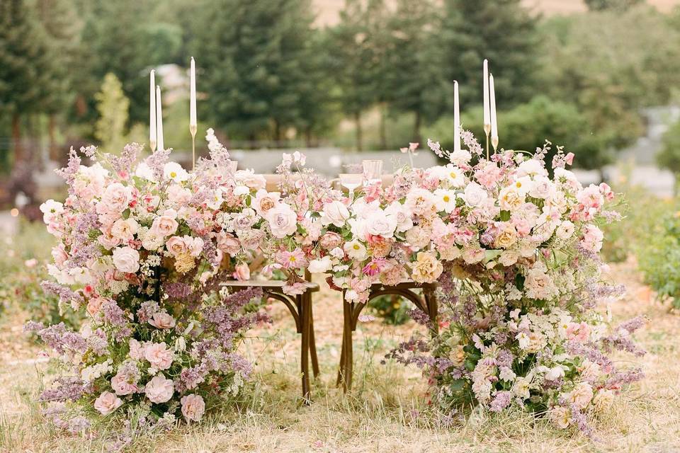 outdoor wedding flower idea english garden wedding theme sweetheart table decorated with pastel flowers and taper candles